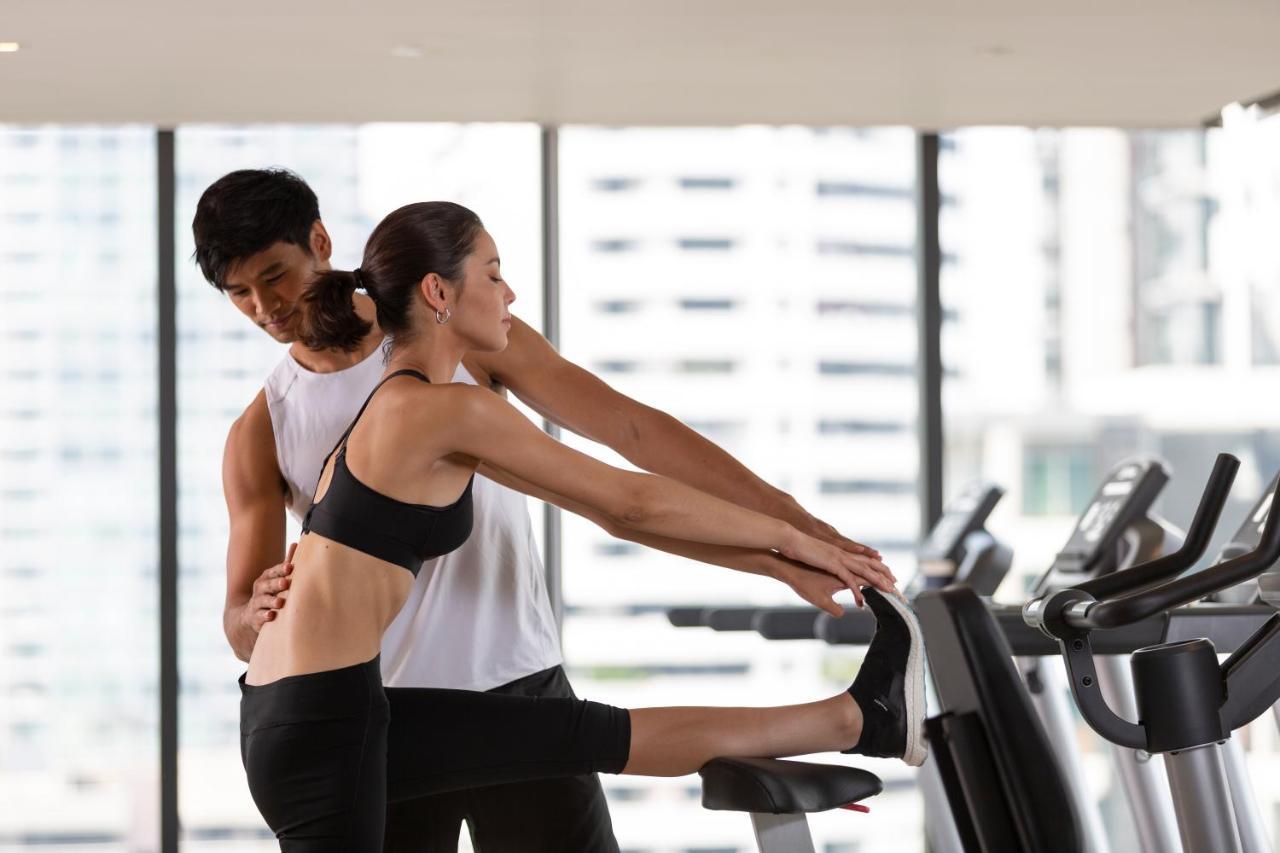 Ascott Thonglor Bangkok Hotel Exterior foto A personal trainer assisting a woman with a stretching exercise